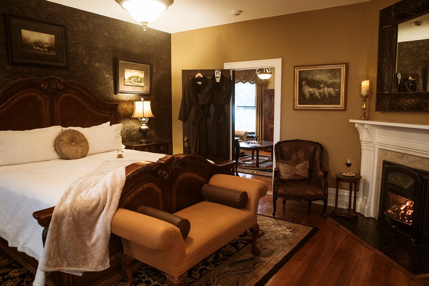 A cozy bedroom featuring a wooden bed, elegant furnishings, and a fireplace.