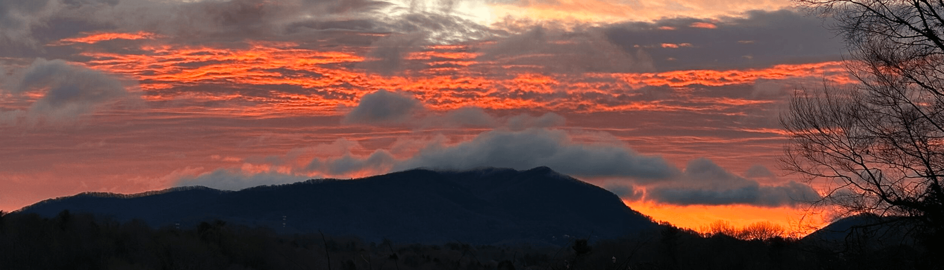 Vibrant sunset paints the sky in shades of orange and pink over distant mountains.