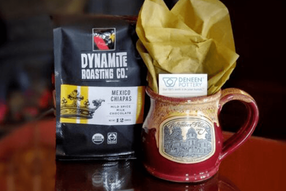 A bag of Dynamite Roasting Co. coffee and a decorative mug filled with tissue paper.