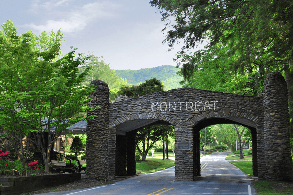 Stone archway entrance marked "Montreat" surrounded by lush greenery and trees.