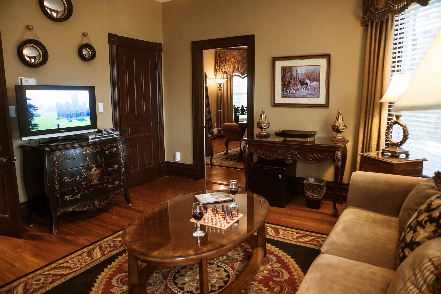 A cozy living room featuring a television, chess set on a coffee table, and elegant decor.