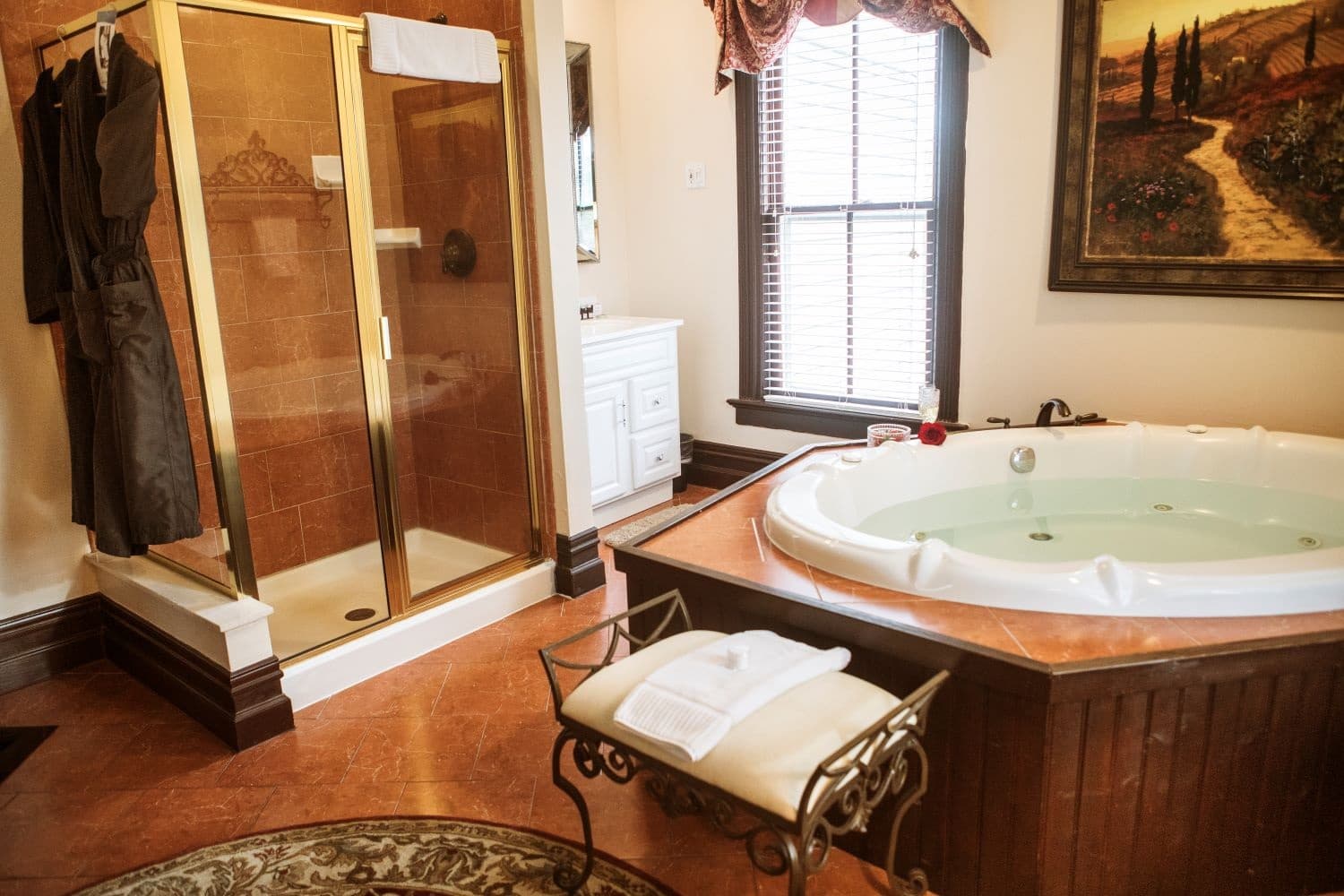A luxurious bathroom featuring a glass shower, a jetted tub, and elegant decor.